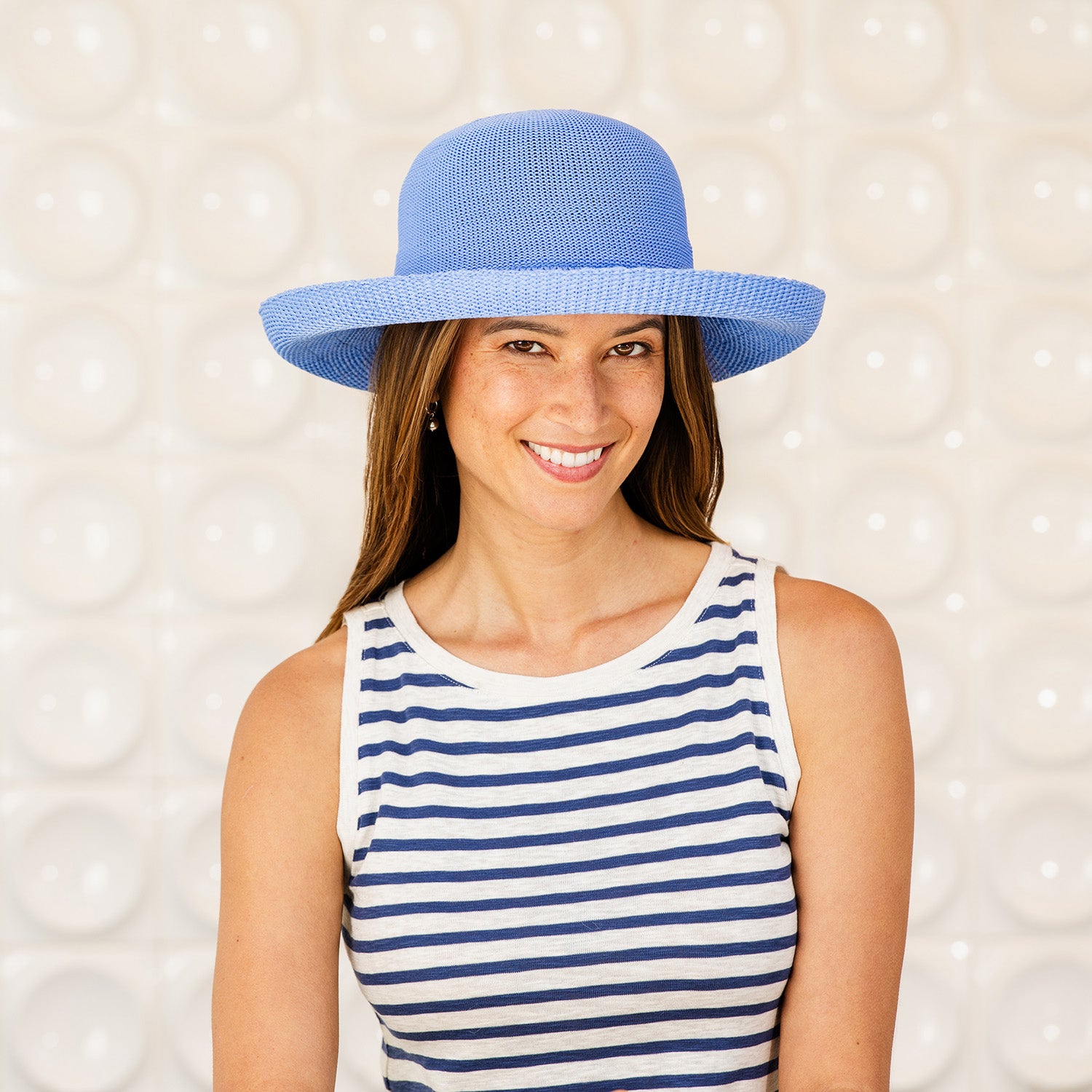 Woman wearing a Victoria sun hat and striped top against a light background, Hydrangea