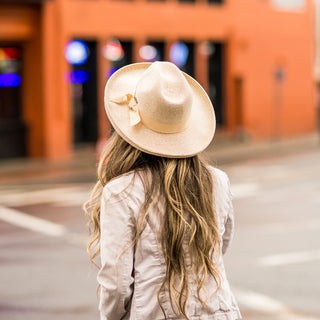 Woman wearing the Carkella Women's Vivian Pencil Brim Fedora Sun Hat while walking the city streets, combining elegance and UPF 50+ sun protection for a fashionable urban look,  White Beige