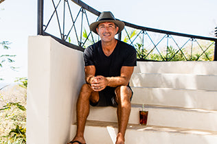 Man in Palm Beach hat sitting on stairs