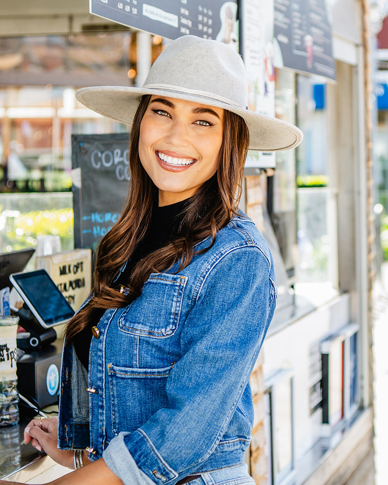 Woman wearing the Colorado wide-brimmed hat and denim jacket in a coffee shop