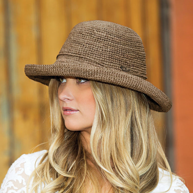Woman Wearing a Wallaroo Catalina Natural Raffia Wide Brim Crown Style Sun Hat in Mushroom